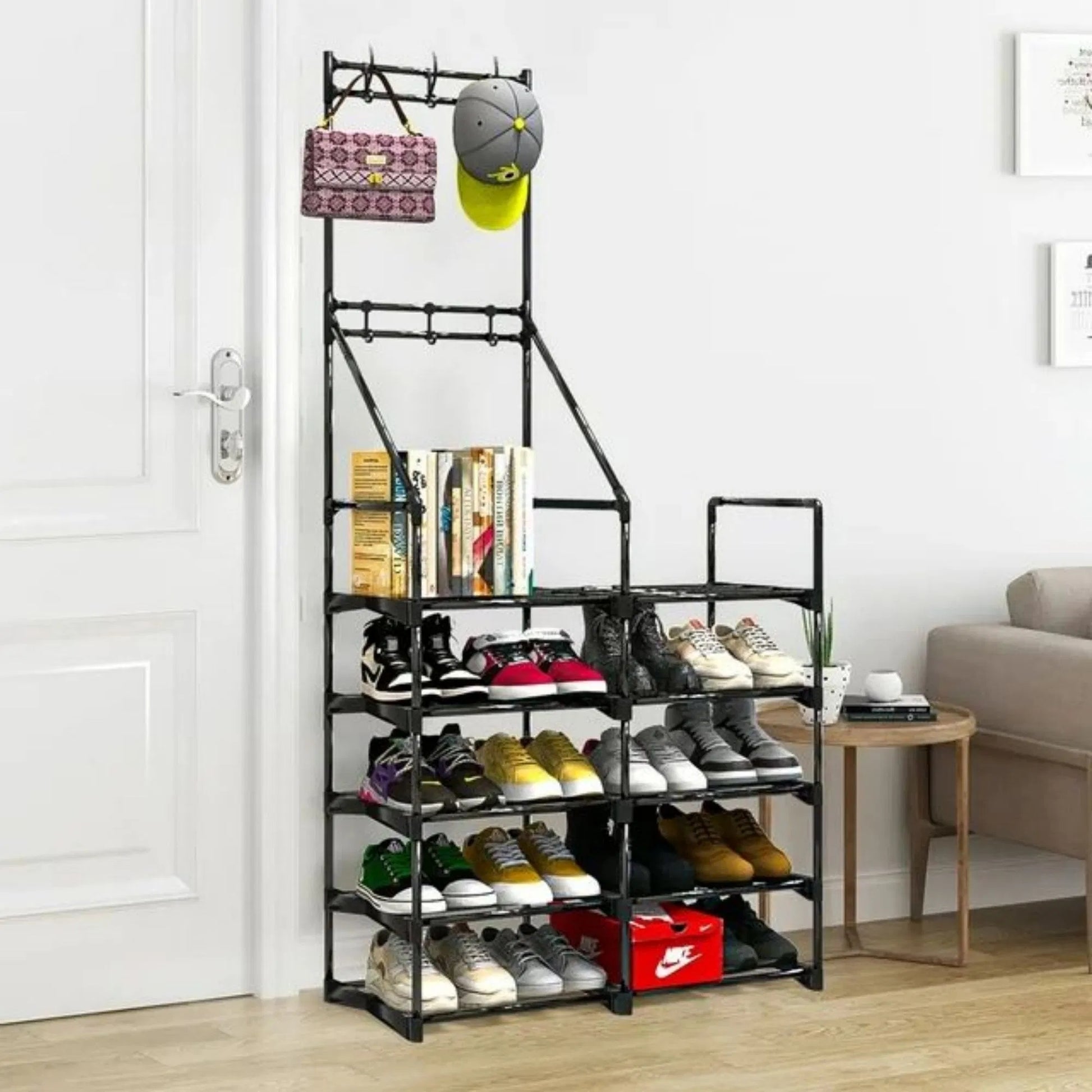 Black metal shoe rack with various shoes and a hat on a wooden floor.