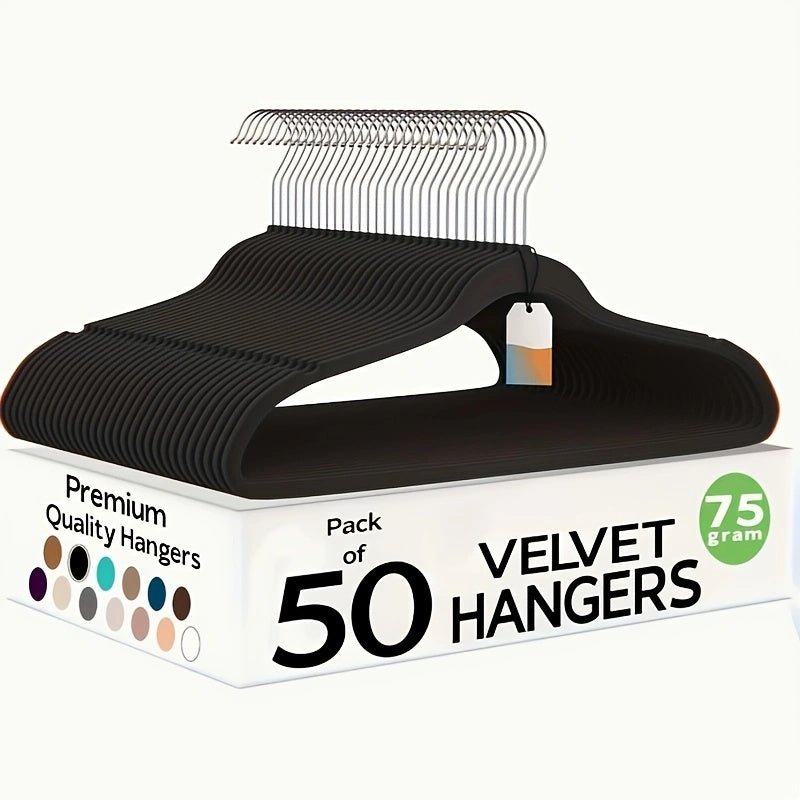 Box of 50 velvet hangers with a single black hanger on top against a white background
