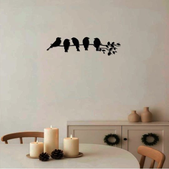 Decorative wall sticker of birds on a branch in a room with candles and a cabinet.