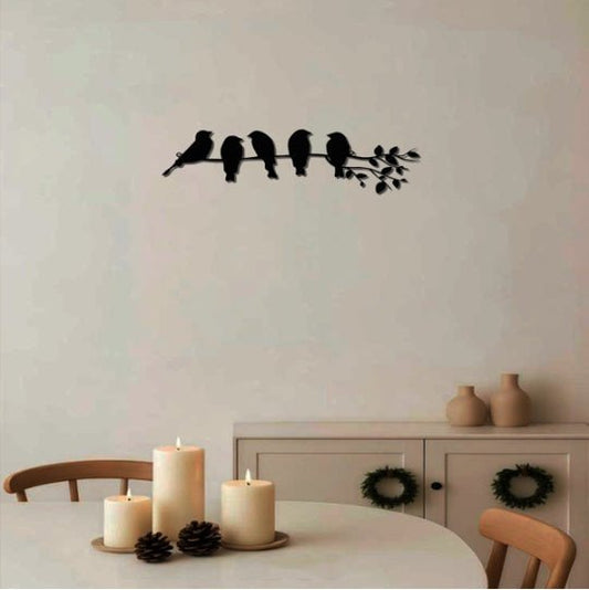 Decorative wall sticker of birds on a branch in a room with candles and a cabinet.