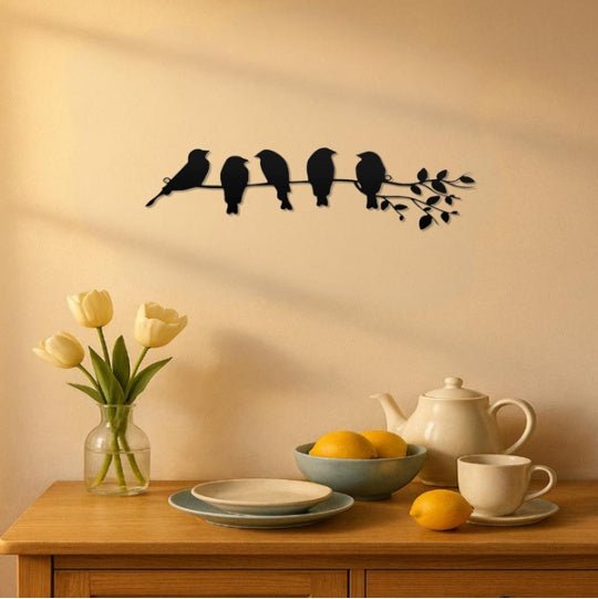 Decorative wall sticker of birds on a branch above a table with tea set and flowers.