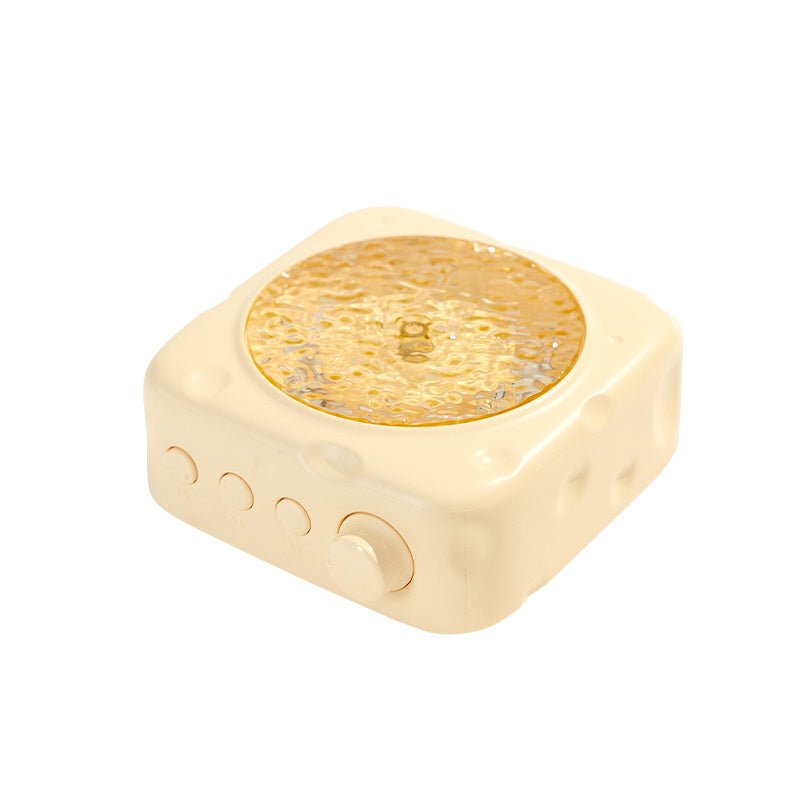 Gold-colored square device with circular design on a white background
