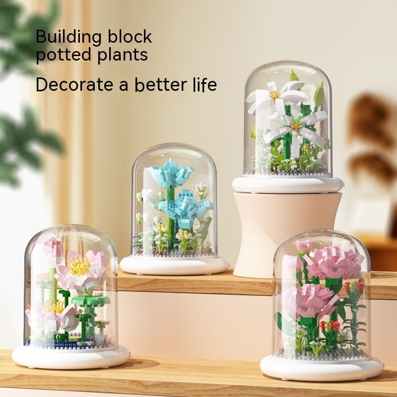 Set of building block potted plants displayed under glass domes on a wooden surface.