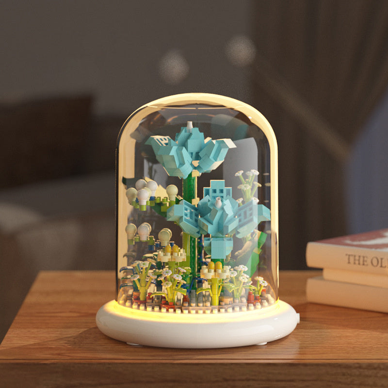 Colorful toy figure inside a glass dome on a wooden surface with a blurred background