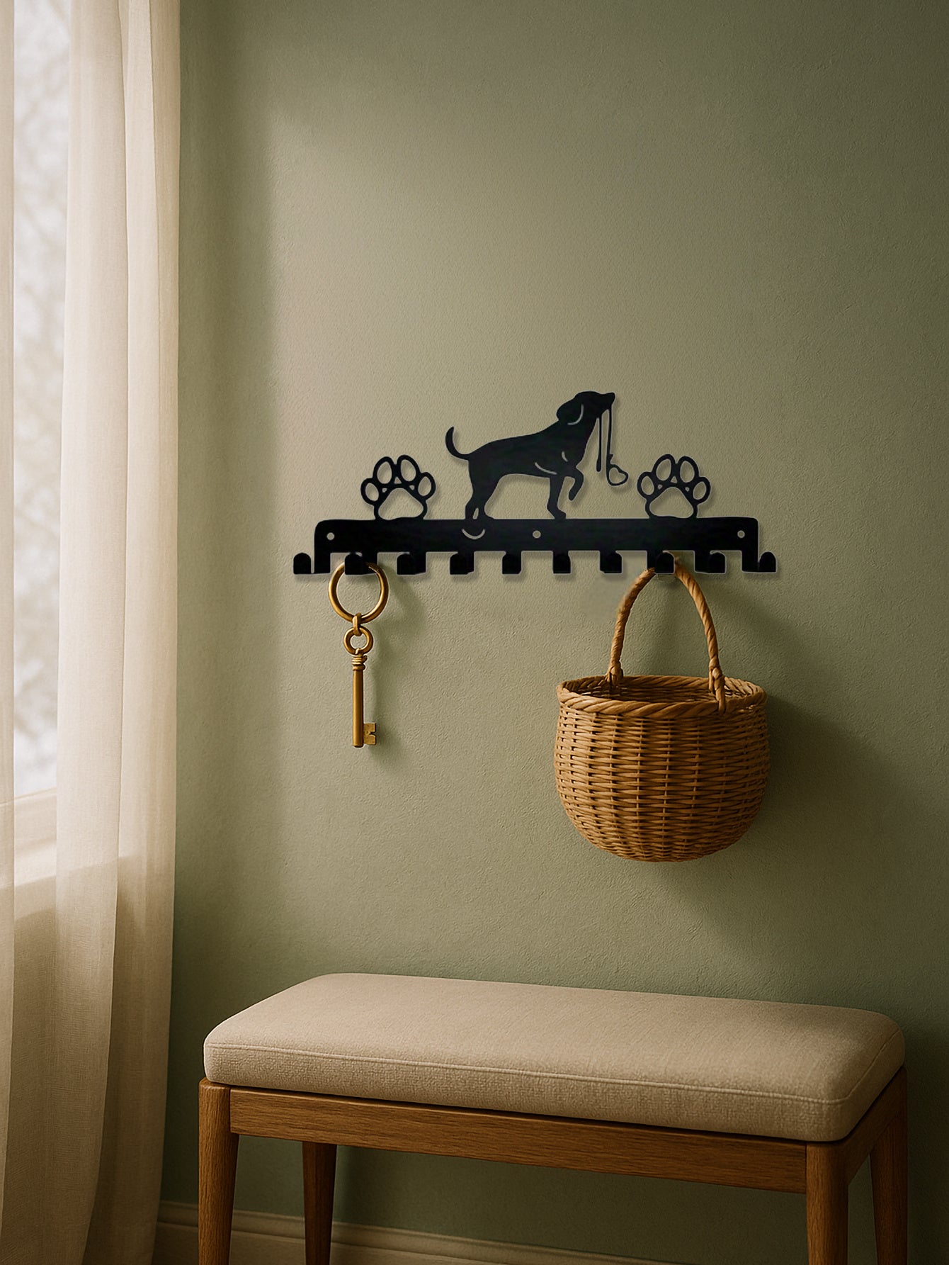 Wall hook with dog design, keys, and basket against a green wall with a bench below.