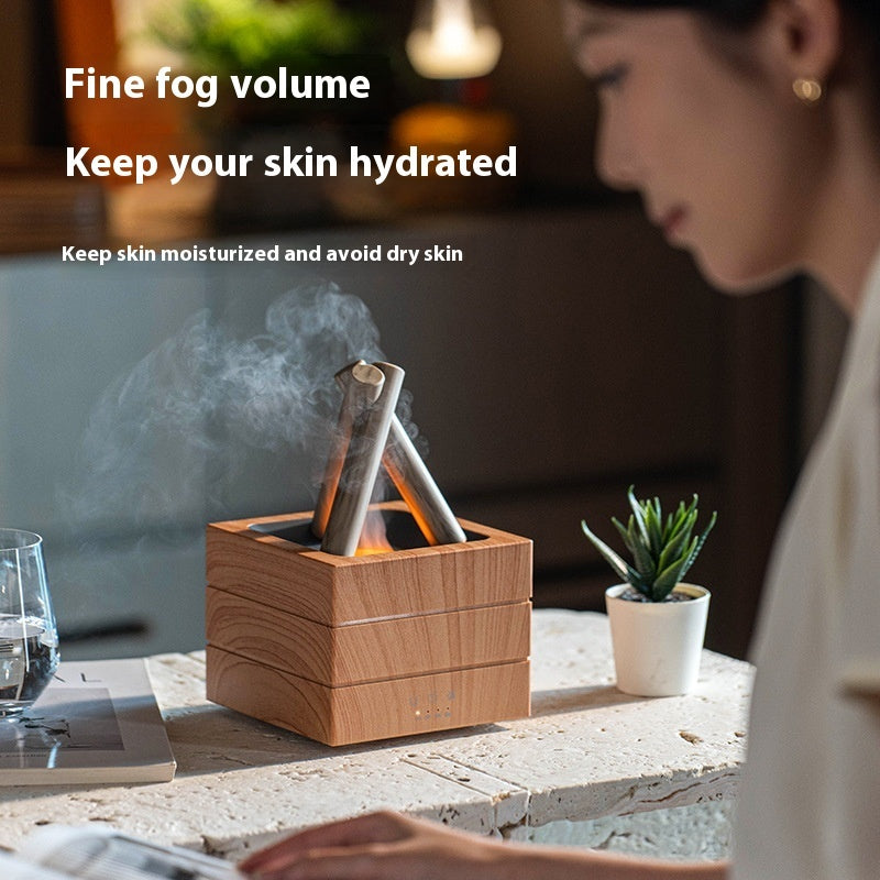 Wooden diffuser emitting fine fog on a table with a person and plant in the background