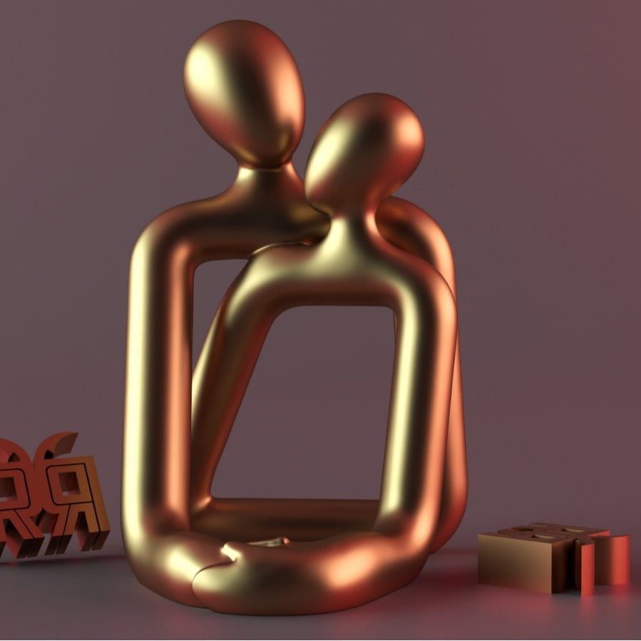 Gold abstract sculpture of two figures embracing on a purple background