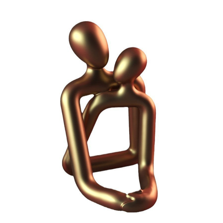 Bronze sculpture of two abstract figures embracing on a white background