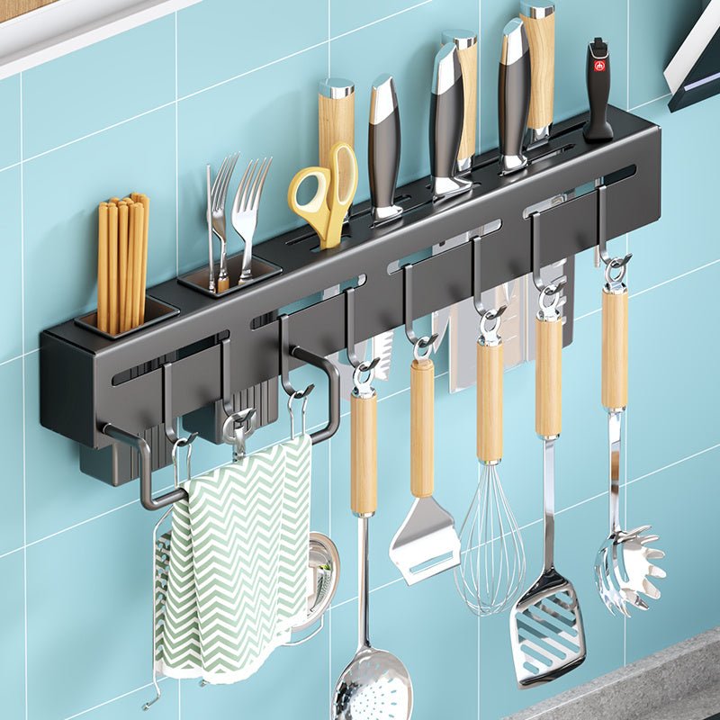 Wall-mounted kitchen utensil holder with various tools on a blue tiled wall.