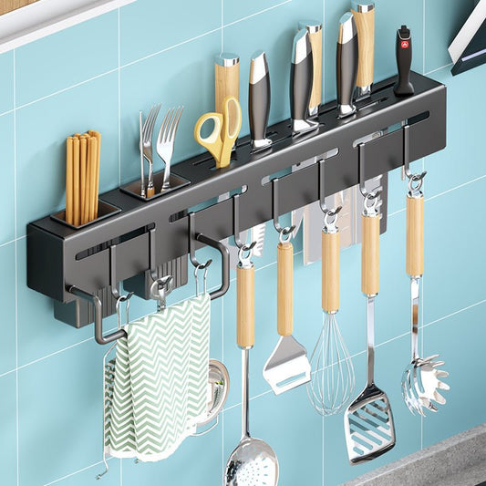 Wall-mounted kitchen utensil holder with various tools on a blue tiled wall.