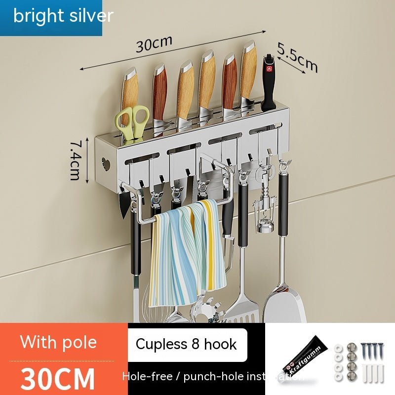 Wall-mounted kitchen organizer with hooks and measurements on a beige wall.