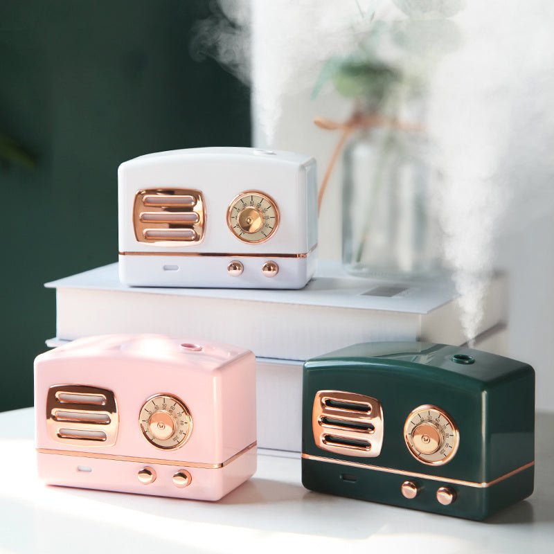 Three vintage-style ceramic radios in white, pink, and green on a white surface with a blurred background.