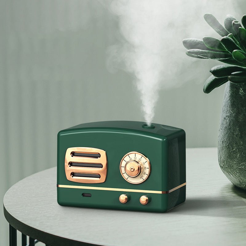 Vintage-style green humidifier with gold accents on a table with a plant in the background