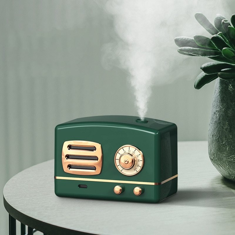 Vintage-style green humidifier with gold accents emitting steam on a light gray surface.